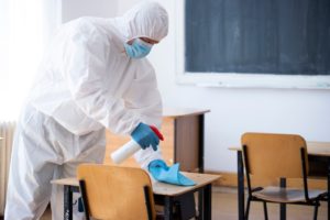 Worker sprays disinfectant as part of preventive measures against the spread of the COVID-19, the novel coronavirus in schools